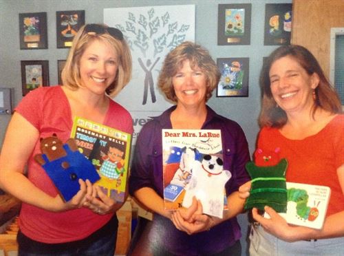 Teachers holding up books